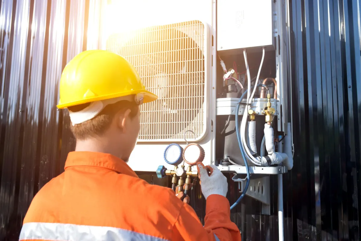 Air-conditioning mechanic servicing an outdoor unit