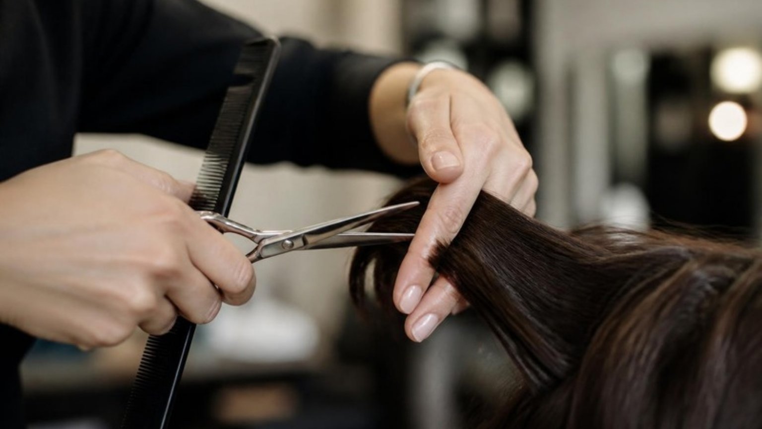 Hairdresser cutting hair with scissors and comb