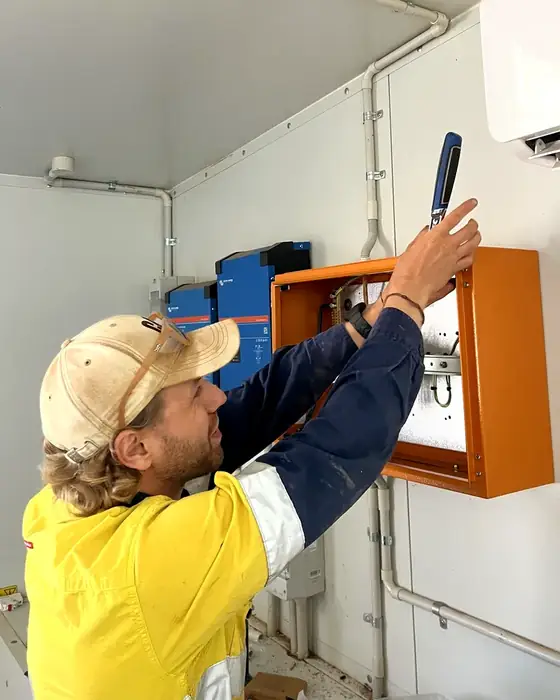 Valentin, founder of Oversix, wiring a switchboard on site